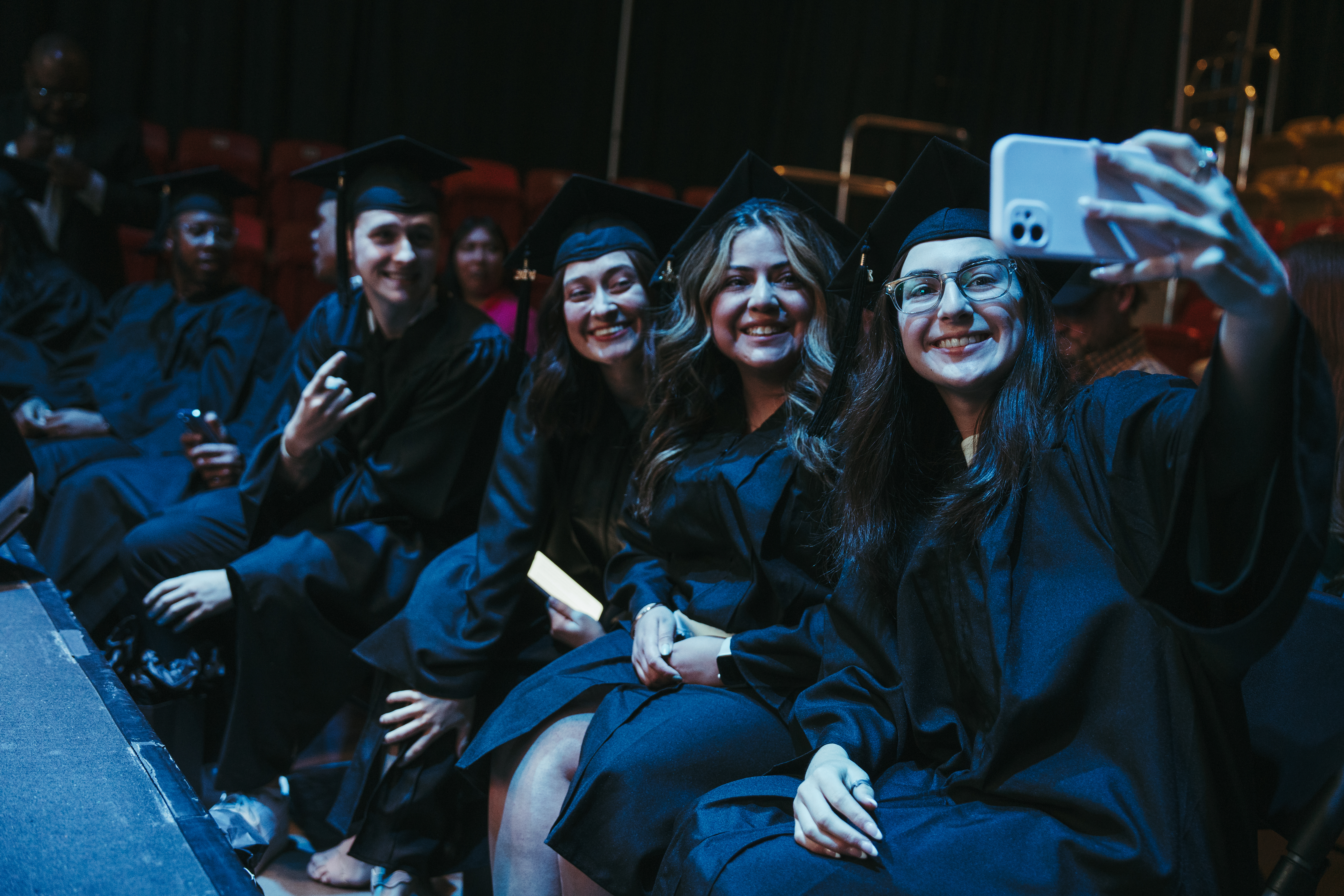 LeadX students taking selfie on in their cap and gowns on graduation day
